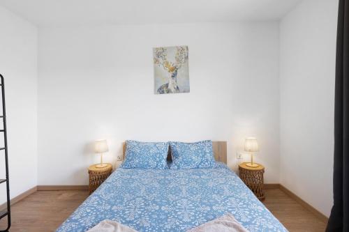 a bedroom with a blue bed with two lamps at Manuel'shouse in Vila Nova de Gaia