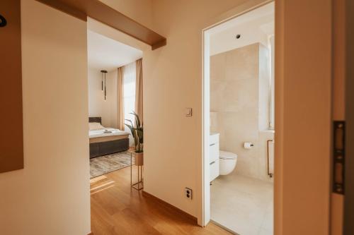 a bathroom with a toilet and a bedroom at CityBeat Apartments, 400m from the square in Pilsen