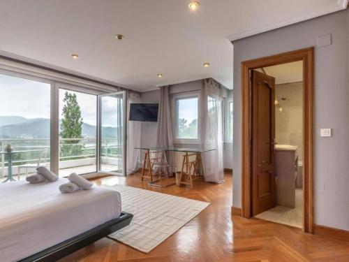 a bedroom with a large bed and a large window at VILLA ISLAS Urdaibai in Isla Becoa