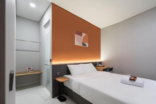 a bedroom with a large white bed with a wooden headboard at Cove Vaia in Bandung