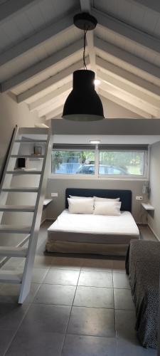a bedroom with a white bed and a staircase at Lea's Studio in Kourouta
