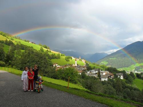 a group of people standing on a road with a rainbow at Maurerhof Telves in Racines