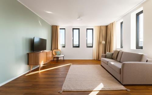 a living room with a couch and a tv at Limehome Gelsenkirchen Hochstr in Gelsenkirchen