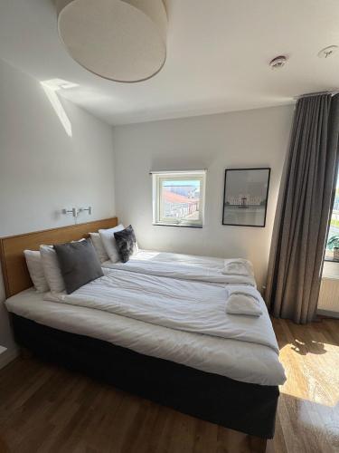 a large bed in a bedroom with a window at Apartments Lund in Lund
