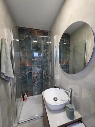 a bathroom with a sink and a shower and a mirror at Morera Suite Paliouri in Paliouri
