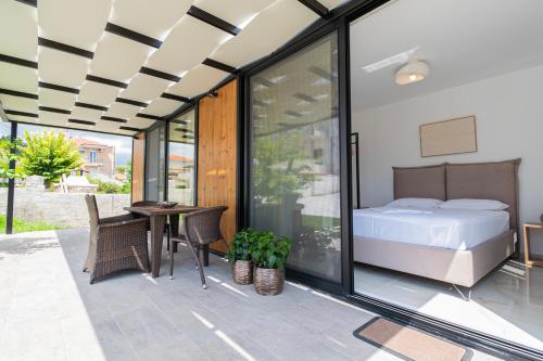 a bedroom with a bed and a table and chairs at Morera Suite Paliouri in Paliouri