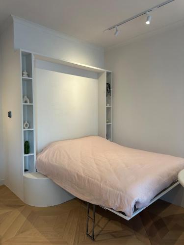 a bedroom with a bed in a white wall at Duin & Zee in Ostend