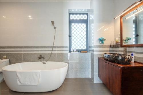a bathroom with a large tub and a sink at Casa De Sol Resort - Wuwei Retreat in Phú Quốc