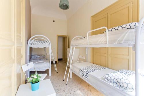 ein Zimmer mit zwei Etagenbetten und einem Tisch in der Unterkunft Moon Light Hostel in Palermo
