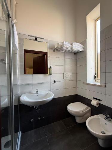 a bathroom with a sink and a toilet and a mirror at Hotel Abay in Rimini