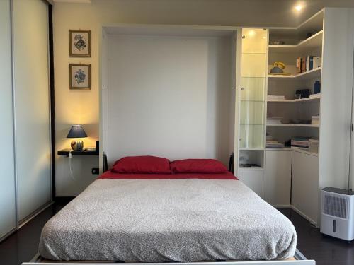 a bedroom with a large bed with red pillows at Nice Gecko in Baveno