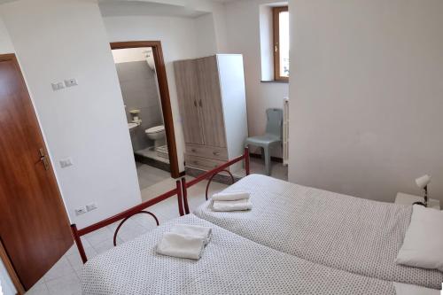 a bedroom with a bed with two towels on it at Ostello del Parco di Monte Cucco in Costacciaro