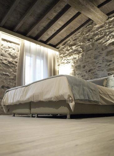 a large bed in a room with a stone wall at Stellio Affittacamere - Guest House in Riomaggiore