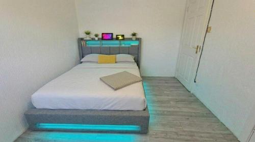 a small bedroom with a bed with blue lights on it at 1 Bedroom studio in Datchet