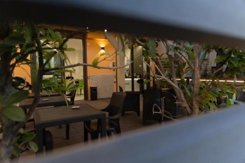a restaurant with tables and chairs and plants at Hotel Giardinetto Al Sant'Orsola in Bologna