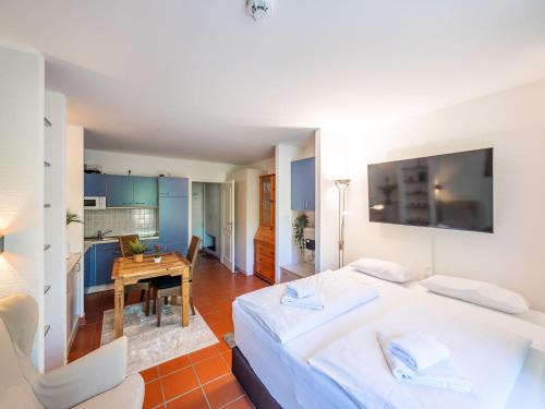 a bedroom with a large bed and a table at Feriendorf Rugana - Klassik 1-Raum Ferienwohnung mit Terrasse B59 in Dranske