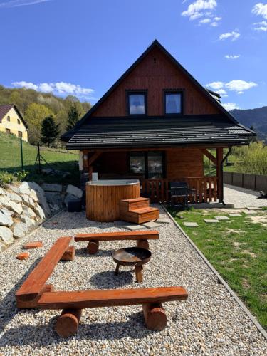 a log cabin with picnic tables in front of it at Chata do Zlatneho in Terchová