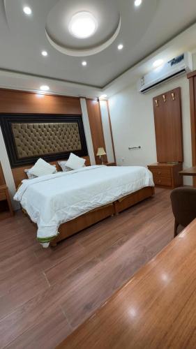 a bedroom with a large bed and a wooden floor at منتجع خيال رفيف in Ḩarshaf