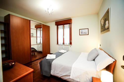 a bedroom with a white bed and a desk at Guest House Sassuolo 2 in Sassuolo