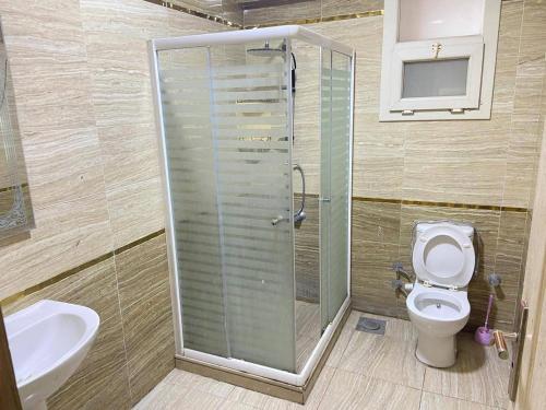a bathroom with a shower and a toilet and a sink at Vera home in Kafr al Ishārah