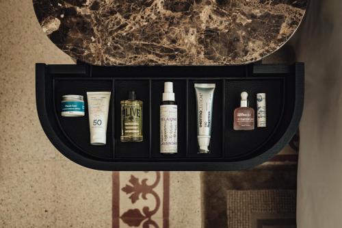 a black shelf with several bottles of hair products at The Phoenicia Malta - The Leading Hotels of the World in Valletta