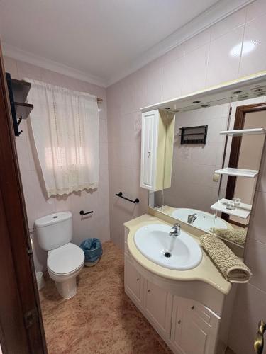 a bathroom with a sink and a toilet and a mirror at Bulevar Carlos III in La Carlota