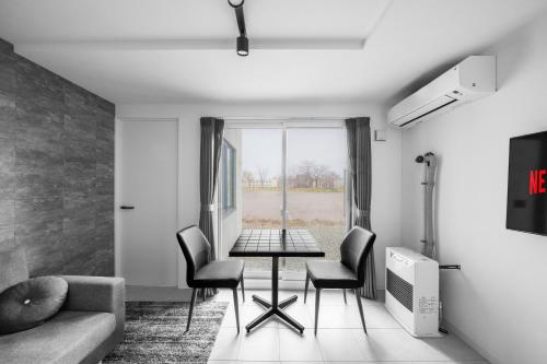 a living room with a table and chairs at Astage Chitose Suehiro 103 in Chitose