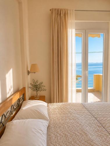 ein Schlafzimmer mit Bett und Meerblick in der Unterkunft Evilion studios in Region Ilia