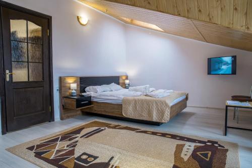 a bedroom with a bed and a door and a rug at Алексік in Truskavets
