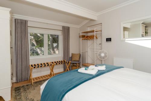 a bedroom with a large bed and a window at Fig Tree Cottage - Leafy Constantia Cottages in Cape Town