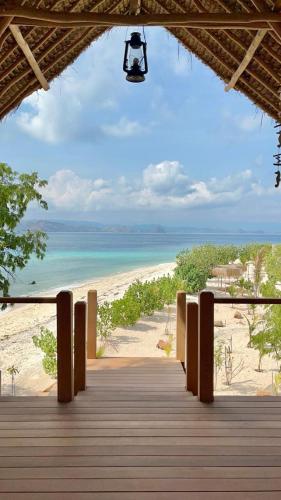 a boardwalk leading to a beach with the ocean at Le Pirate Island - Adults Only in Labuan Bajo