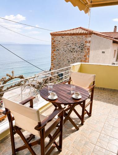 Ein Tisch und Stühle auf einer Terrasse mit Blick auf das Meer in der Unterkunft Evilion studios in Region Ilia