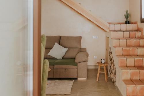 a living room with a couch and a staircase at Suite ideal para escapadas romanticas in Bullas