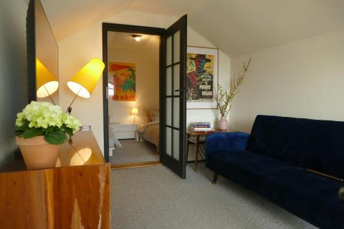 a living room with a blue couch and a mirror at Bosco Due in Łagów