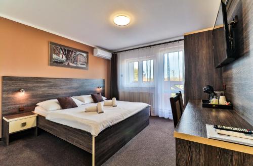 a bedroom with a large bed with a wooden headboard at Třebovický mlýn in Ostrava