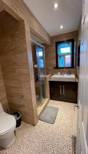 a bathroom with a toilet and a shower and a sink at Luxury KIA Room D in Richmond Hill