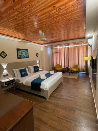 a bedroom with a large bed with a wooden ceiling at Hunza Embassy Hotel by Zeez in Karimabad Hunza