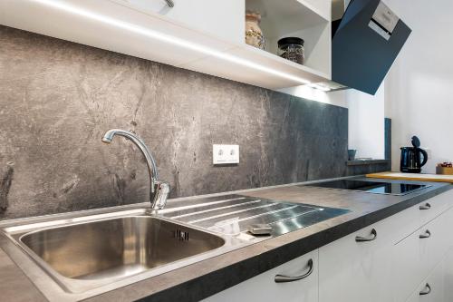 a kitchen with a stainless steel sink and a counter at Richard´s Home Auer in Auer