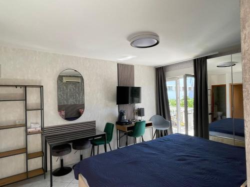 a bedroom with a blue bed and a desk and a table at Apartments Vodice in Vodice