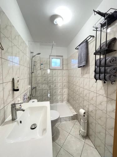 a white bathroom with a sink and a toilet at Apartments Vodice in Vodice
