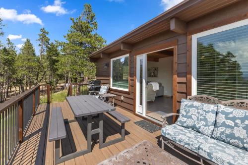a wooden deck with a table and a couch at Stone Cliff Cottage in Golden