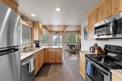 a kitchen with stainless steel appliances and wooden cabinets at Stone Cliff Cottage in Golden