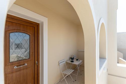a hallway with a wooden door and a table at Vivlos Stays - Ageri in Vívlos