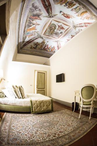 a bedroom with a bed and a painting on the ceiling at Hotel Burchianti in Florence