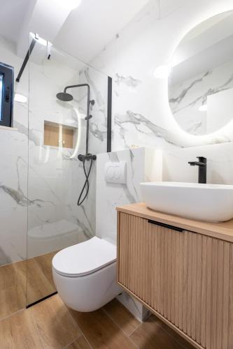 a white bathroom with a toilet and a sink at Azure Adriatic in Prožura