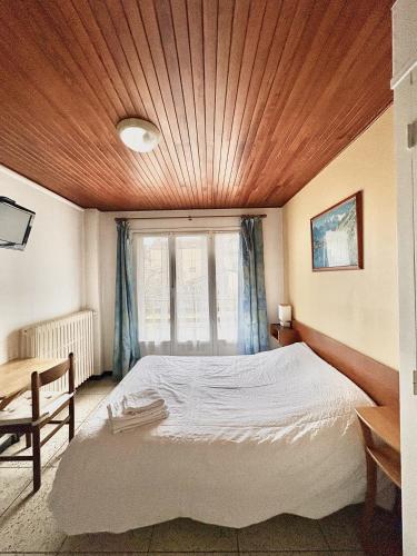 a bedroom with a large bed with a wooden ceiling at Les Loges du Vercors in Vizille