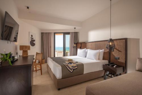 a hotel room with a bed and a desk and a bed at Oya Beach Resort in Hersonissos
