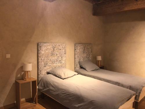 two twin beds in a room with two lamps at La Maison Forte in Courtenay