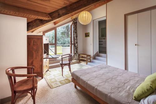 a bedroom with a bed and a desk and chairs at Chambres hôtes Le Champ Des Oiseaux in Rochechouart