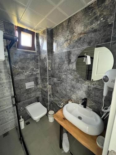 a bathroom with a sink and a toilet at Bergüzar Hanım Konukevi in Gokceada Town